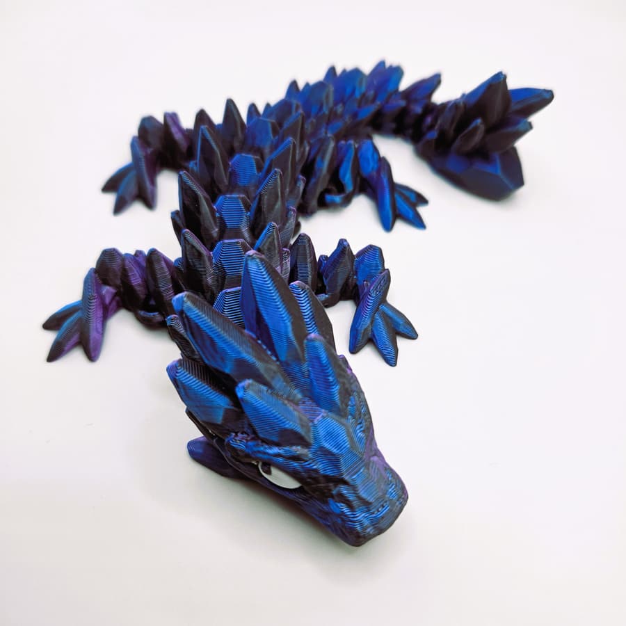 3D-printad babydrake i blått, lila och svart
